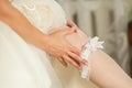 Sexual bride putting on wedding garter. Bride`s hands