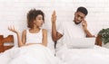 African workaholic husband ingnoring his iiritated wife in bed