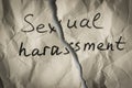 Sexual harassment concept. Torn pieces of crumpled paper with the words sexual harassment