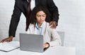 Sexual harassment in office. African American boss molesting his female employee at workplace