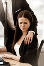 Sexual harassment at work. Male businessman puts hand on annoyed female assistant shoulder at workplace showing