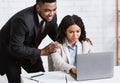 Sexual harassment at workplace. African American male boss touching his beautiful female secretary at company office Royalty Free Stock Photo