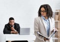 Sexual intimidation concept. Perverted black businessman looking at his female colleague from behind at office Royalty Free Stock Photo