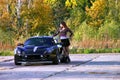 Sexual young woman standing near low sport car Royalty Free Stock Photo