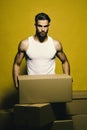 Sexuality and building concept. Guy with muscular torso holds box in front. Loader with serious face wears white Tshirt Royalty Free Stock Photo