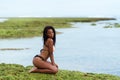 Sexy african american model in swimwear posing on beach. Dark skinned girl resting on tropic island Royalty Free Stock Photo