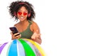 Sexy african woman in sunglasses and a swimsuit holds the phone in her hands and listens to music Royalty Free Stock Photo