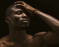 Sexy Afro-American man shows face palm gesture. portrait of a naked man standing with closed eyes on black background Royalty Free Stock Photo