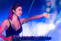 Sexy asian Dj mixing music in the club party. female disc jockey on turntable in nightclub enjoying mixing sound music.