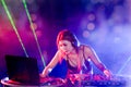 Sexy asian Dj mixing music in the club party. female disc jockey on turntable in nightclub enjoying mixing sound music.