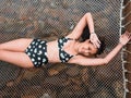 Sexy Asian woman in bikini lay down on hammock net over the tropical beach In Koh Kut Island, Thailand. Royalty Free Stock Photo