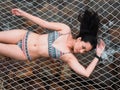 Sexy Asian woman in bikini lay down on hammock net over the tropical beach In Koh Kut Island, Thailand. Royalty Free Stock Photo