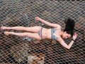 Sexy Asian woman in bikini lay down on hammock net over the tropical beach In Koh Kut Island, Thailand. Royalty Free Stock Photo