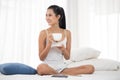 Sexy asian woman holding a cup of tea and sitting on the bed Royalty Free Stock Photo