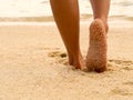 Sexy Asian women legs foot step on tropical sand beach. Walking female feet sand beach leaving footprints