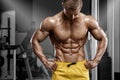 athletic man showing muscular body and sixpack abs in gym. Strong male nacked torso, working out