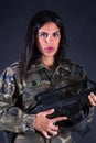 Sexy attractive brunette female soldier posing with weapons in studio. Royalty Free Stock Photo