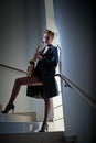attractive woman with saxophone and long legs posing on stairs. Young attractive blonde playing sax. Musical instrument. Jazz Royalty Free Stock Photo
