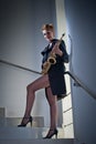 attractive woman with saxophone and long legs posing on stairs. Young attractive blonde playing sax. Musical instrument. Jazz Royalty Free Stock Photo