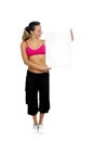 attractive woman in sport pants and gym bra holding blank billboard card with copy space Royalty Free Stock Photo