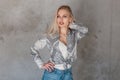 Sexy attractive young woman a blonde in a fashionable shirt with a pattern in a trendy t-shirt in stylish jeans in the studio