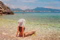 Sexy back of beautiful woman in bikini and creative hat on sea background. Sea coast near Kemer, Antalya, Turkey Royalty Free Stock Photo