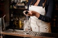 barman girl pouring vodka into a cocktail glass