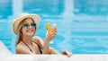 Sexy beach girl with tasty cocktail enjoying her summer vacation at swimming pool, free space