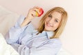 beautiful blond young woman girl holding apple happy smiling & looking at camera Royalty Free Stock Photo