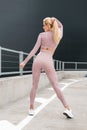 Sexy beautiful fitness blonde model woman with slim fit body and booty in fashion sportswear with white jogging sneakers and pink Royalty Free Stock Photo