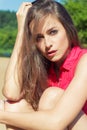 beautiful girl with long dark hair sitting in denim shorts on the beach in Sunny day Royalty Free Stock Photo