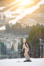 beautiful naked girl standing on the snowy slope of the mountain, wearing helmet, ski, and backpack Royalty Free Stock Photo
