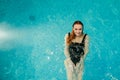 sexy beautiful reddish woman in black bath costume swimming backstroke in the swimming pool of a spa centre