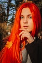 Sexy beautiful redhead girl with long, strong and thick hair. Perfect woman portrait on a background of autumn foliage. Gorgeous Royalty Free Stock Photo