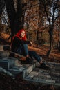 Sexy beautiful redhead girl with magnificent long hair. Ukulele playing, sitting on the steps in the park. Perfect woman portrait Royalty Free Stock Photo