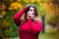 Sexy beautiful woman in autumn, cute plus size model in red sweater outdoors