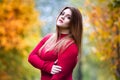 Sexy beautiful woman in autumn, cute plus size model in red sweater outdoors