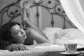 beautiful woman in underwear relaxes on a bed in hotel room. close-up of a tea mug. black and white Royalty Free Stock Photo