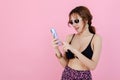 Sexy beautiful women with sunglass using smartphone pink background. portrait beautiful female use mobile phone. summer vacation