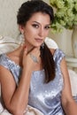 beautiful young brunette woman with evening make-up chic groomed wearing a short evening dress embroidered with silver