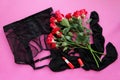 Sexy belt with stockings and red roses, red lipstick on pink background top view Royalty Free Stock Photo