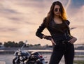 Sexy biker girl in leather jacket posing at sunset Royalty Free Stock Photo