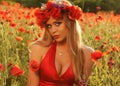 blond girl in elegant dress posing in summer field of red poppies Royalty Free Stock Photo