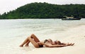 blond woman in bikini relaxing on beach in Thailand Royalty Free Stock Photo