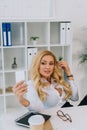 sexy blonde businesswoman taking selfie at working place Royalty Free Stock Photo