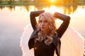 sexy blonde woman in black leather jacket and shorts with white angel wings. demon or angel in hell or heaven. sunset Royalty Free Stock Photo