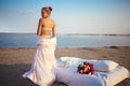 Sexy Blonde Woman in lingerie Holds Flower bouquet On Beach At Sunset. Royalty Free Stock Photo