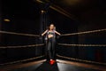 boxing girl stands leaned on ropes of competition ring.