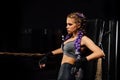 boxing girl stands leaned on ropes of competition ring.