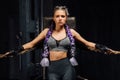 boxing girl stands leaned on ropes of competition ring.